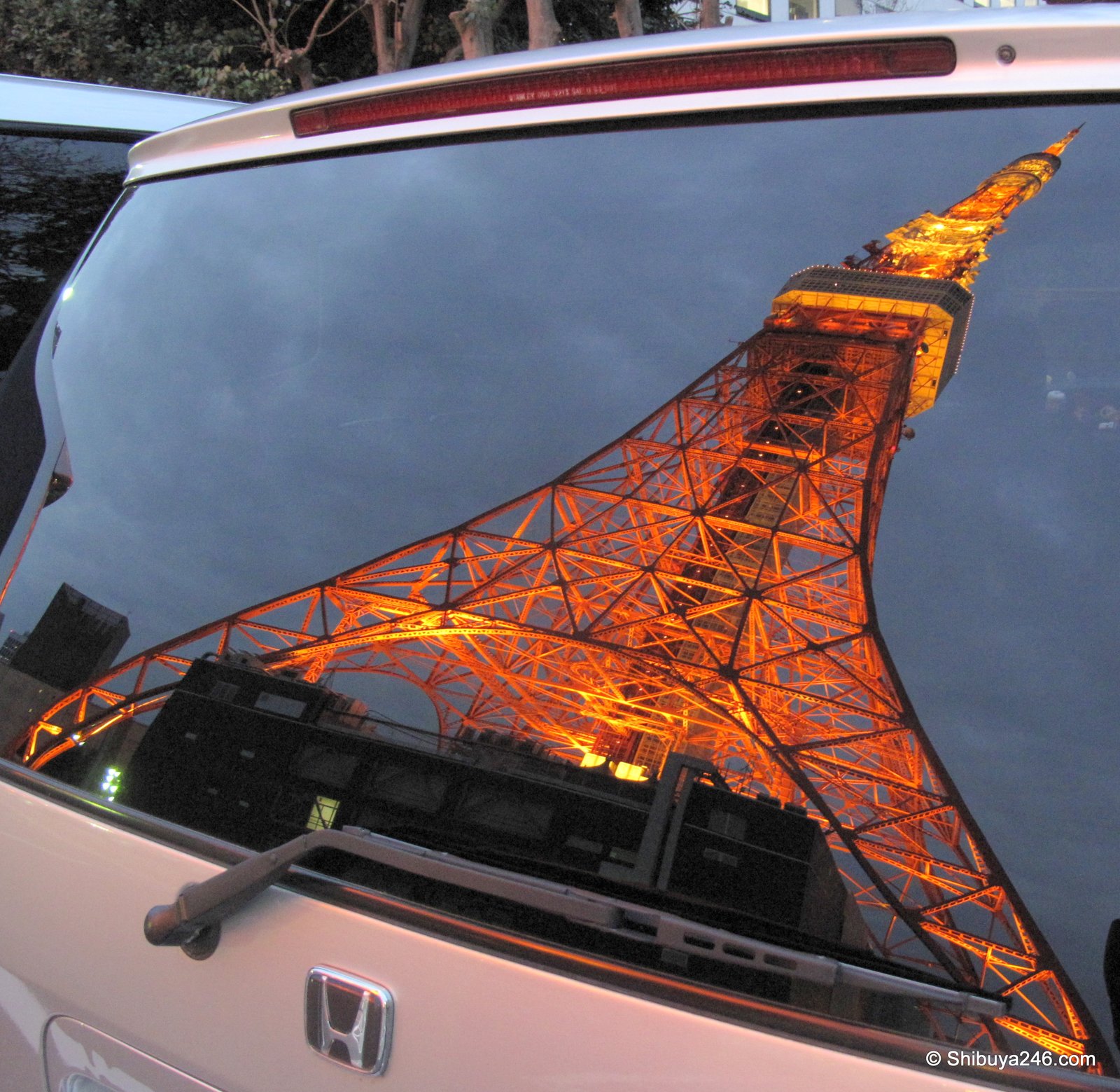 Tokyo Tower on a Honda: the lit-up tower in the back window of a parked car.