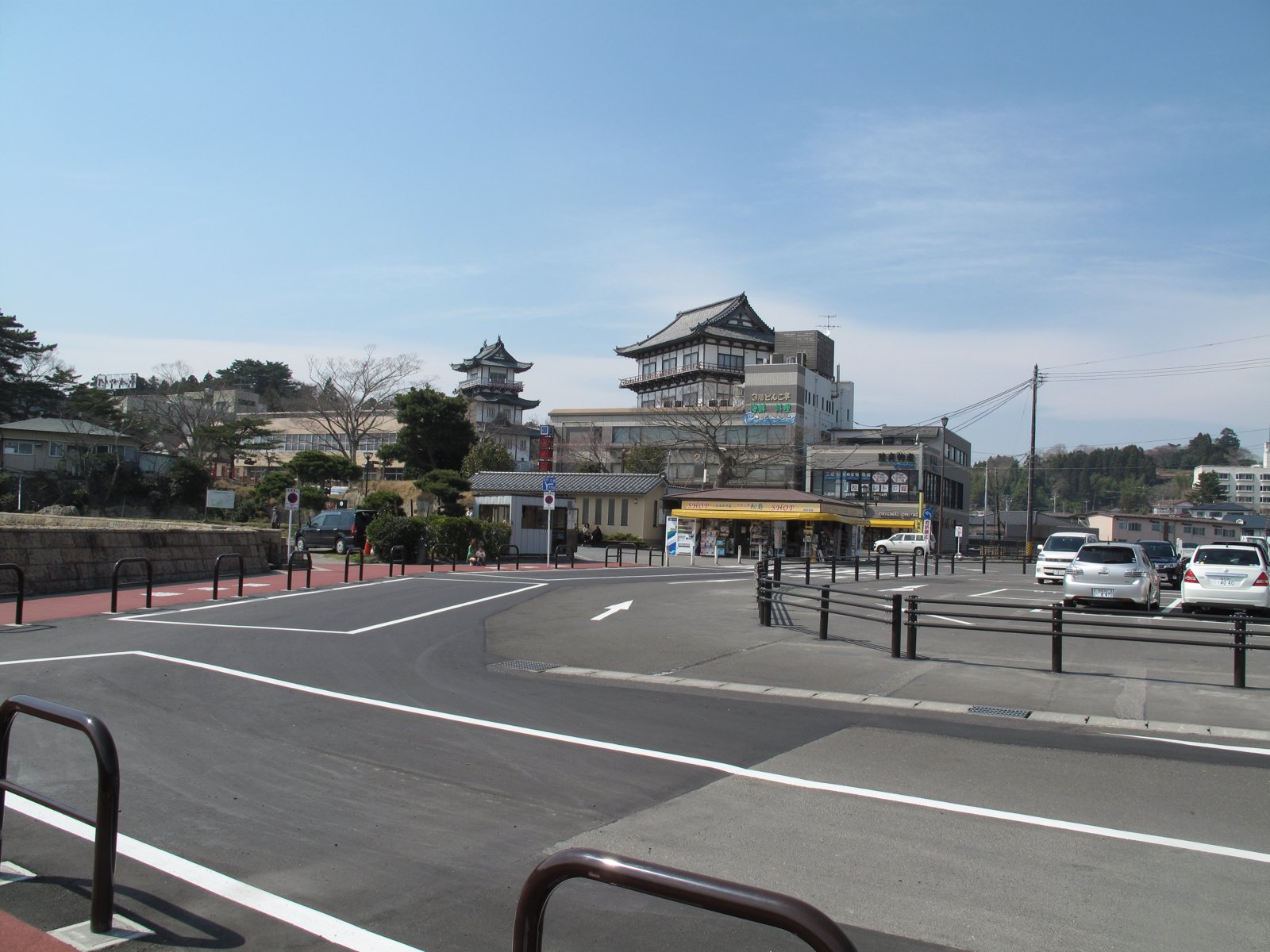 A waterfront road with a temple-style building