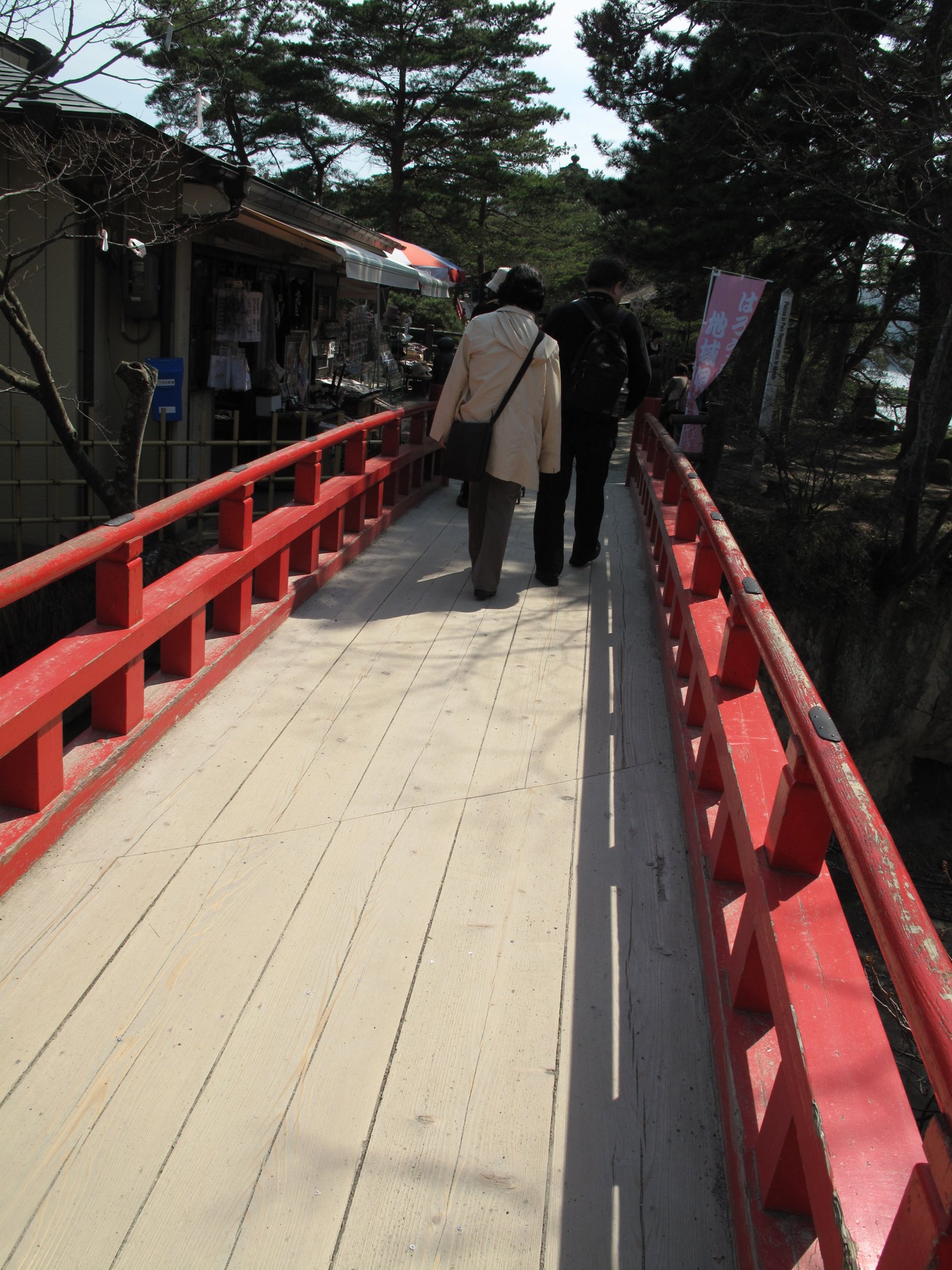 Walking across a red bridge with wooden planks