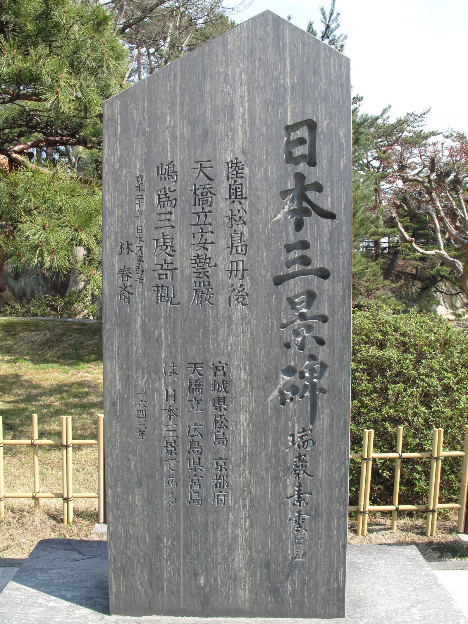 A tall wooden marker carved with 日本三景