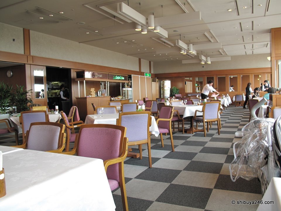 A restaurant with pink chairs and large windows