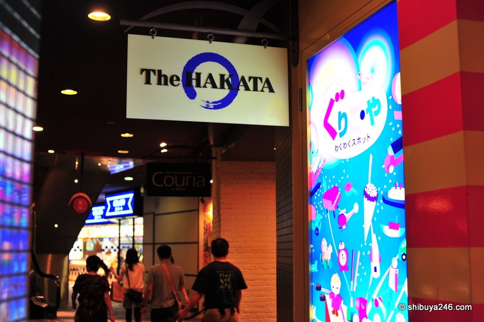 A brightly lit shop entrance with people walking in