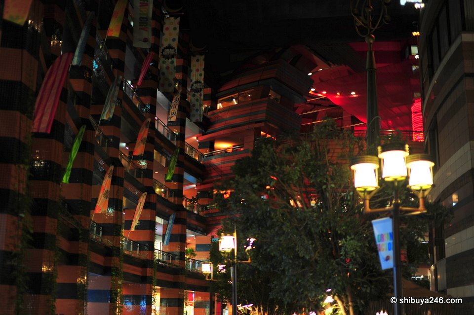 Red walls and a street lamp among trees at night