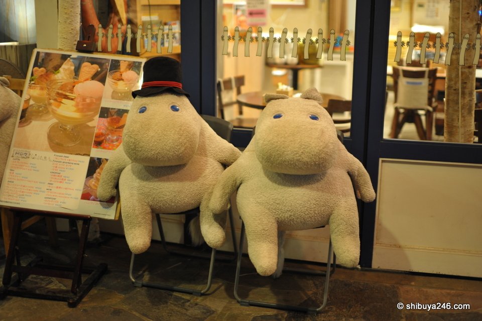 Two large white stuffed toys sitting outside a shop