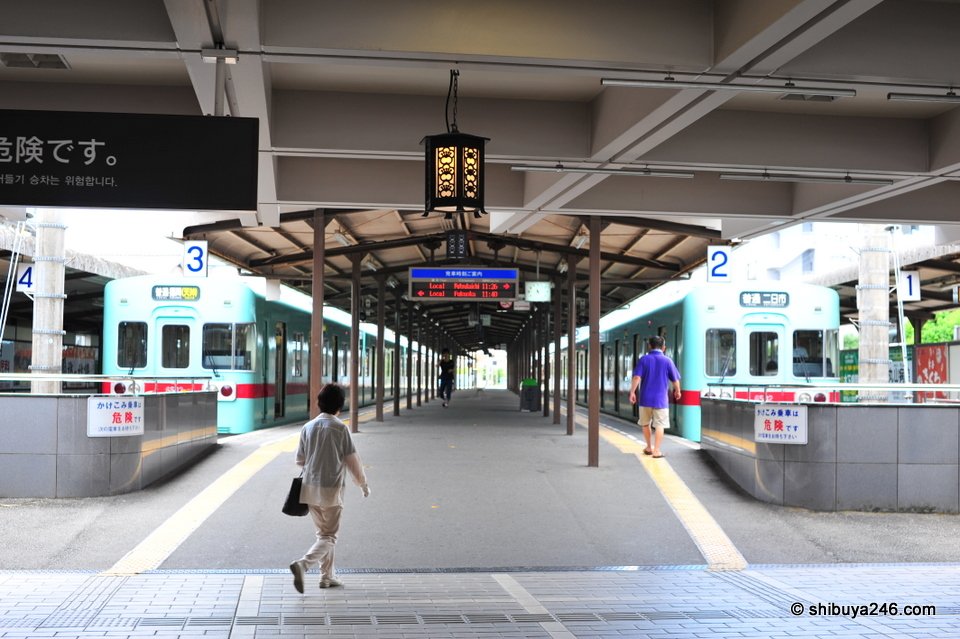 A station concourse with lanterns and trains behind