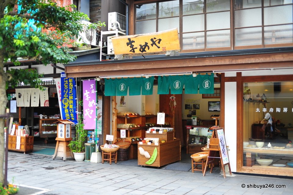 A shop with a yellow sign and goods outside