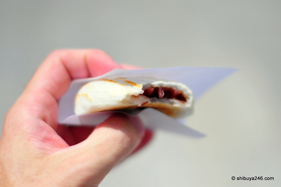 A hand holding a grilled rice cake