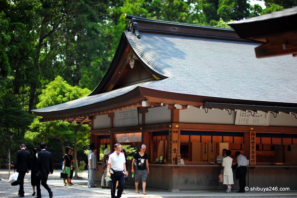A wooden building with an amulet counter and visitors