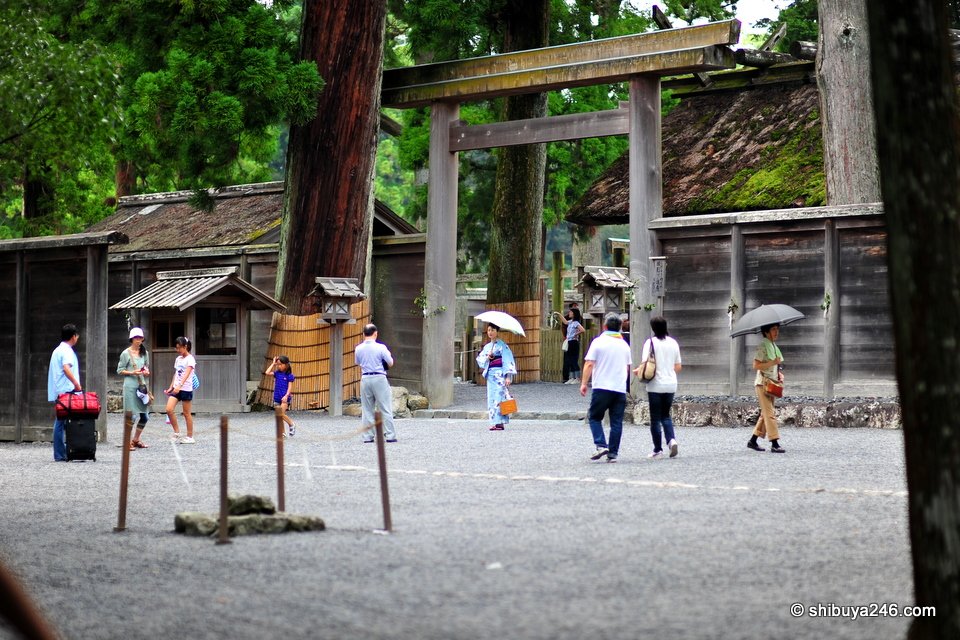 A torii and wooden buildings beside a gravel square