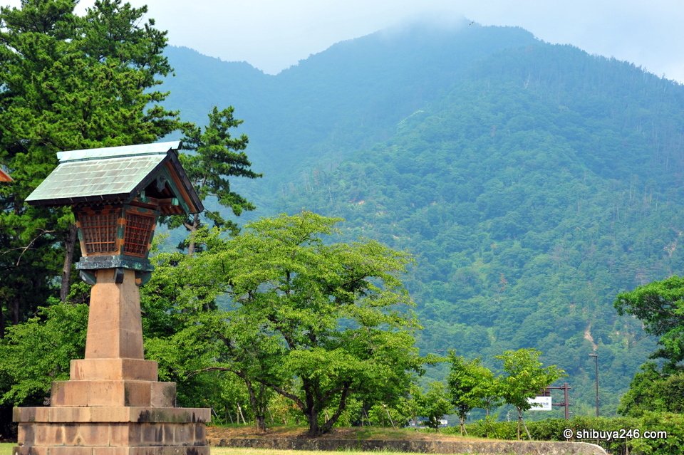 A stone lantern with forested mountains behind