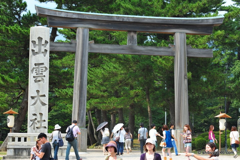 Visitors walking under a stone torii