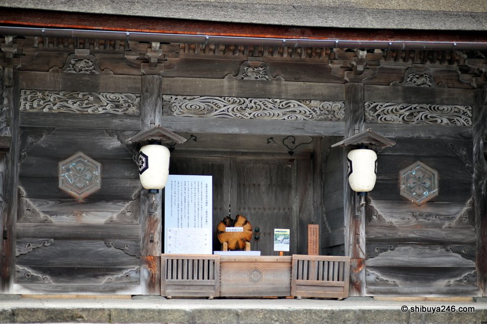 An old wooden side shrine with carved panels