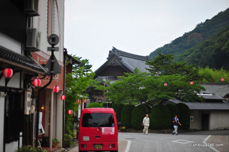 A town street with paper lanterns and a red van