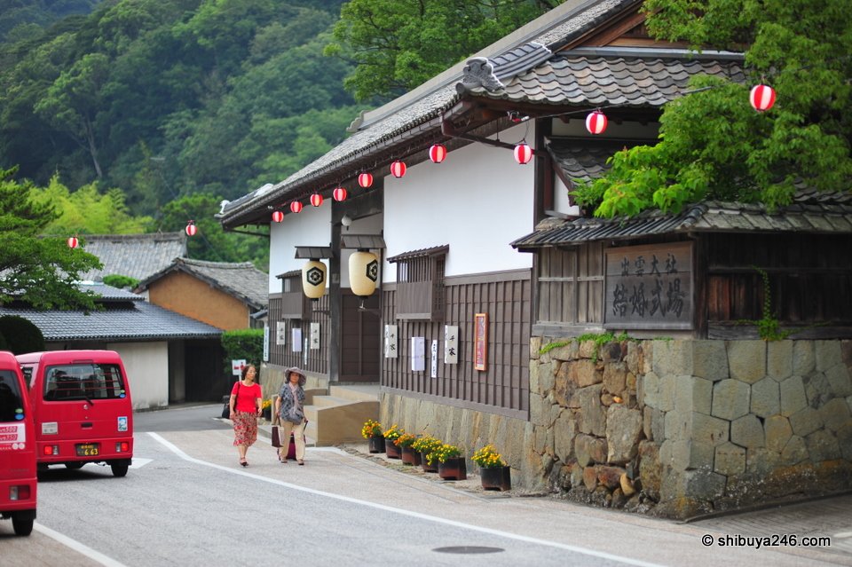 A white-walled old building with lanterns along the eaves