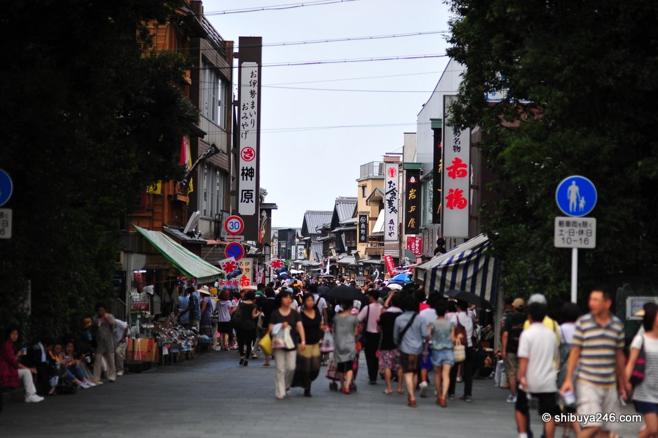 A busy shopping street with crowds and old shopfronts