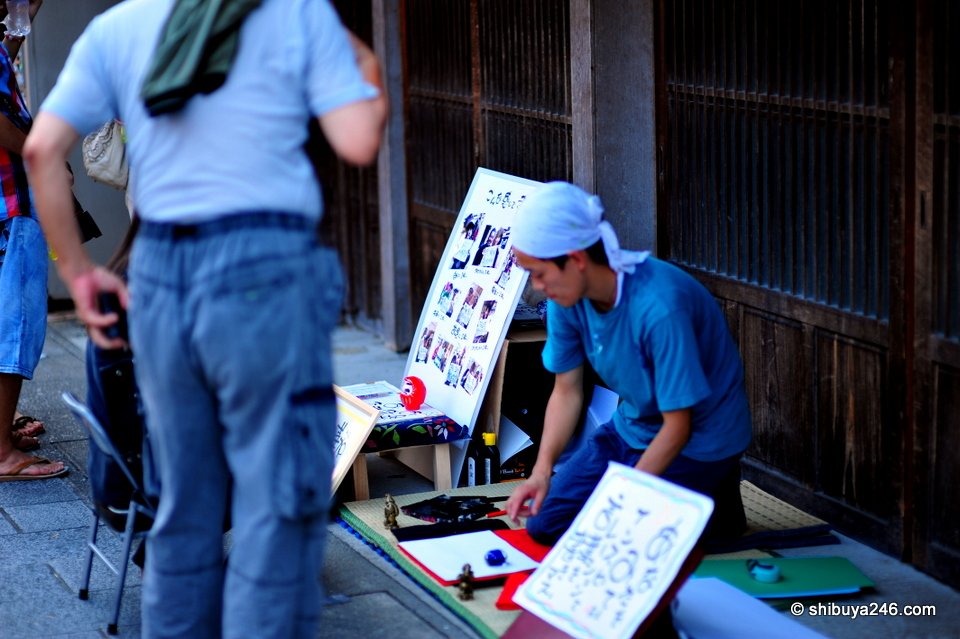 A craftsman writing at a table in a shop doorway