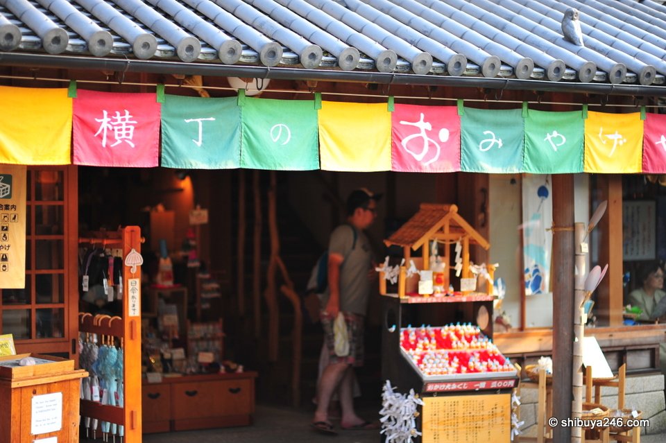 A shopfront with colourful banners and a small shrine