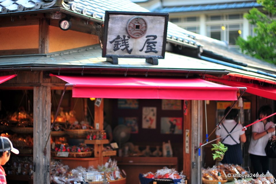 A shop with a red awning and a wooden sign