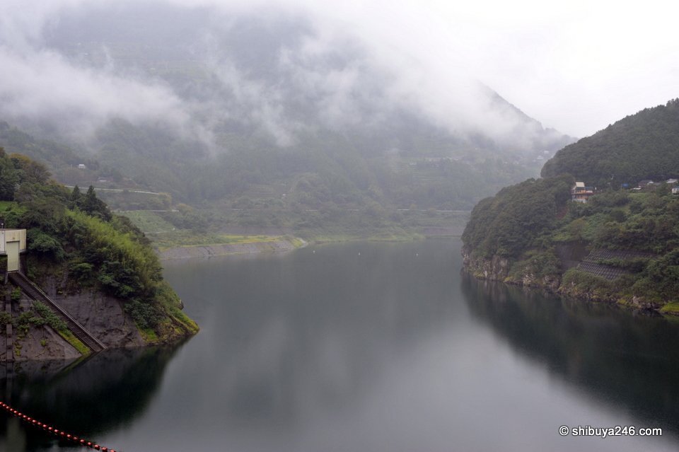 A misty lake between steep wooded hills