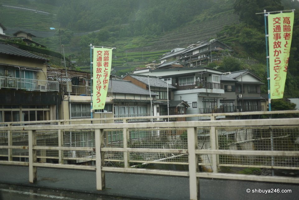 Houses and banners on a hillside above the river