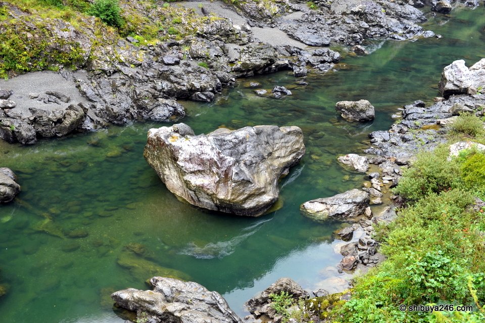 A large white rock in clear green river water