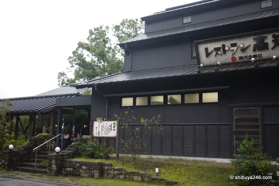 A dark wooden restaurant building beside the road