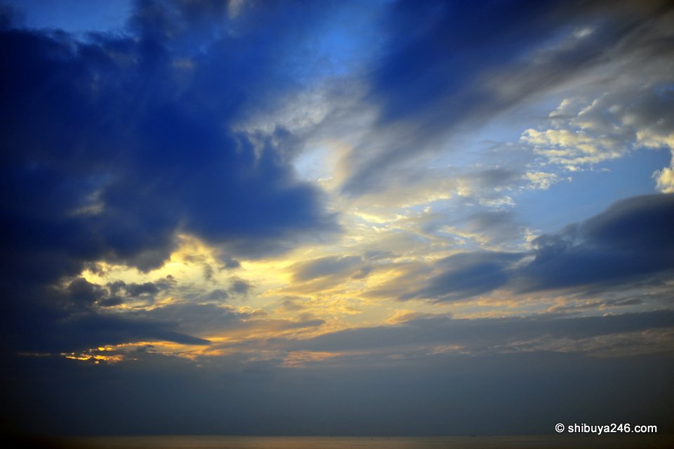 Dark blue clouds with a band of golden light over Awaji Island