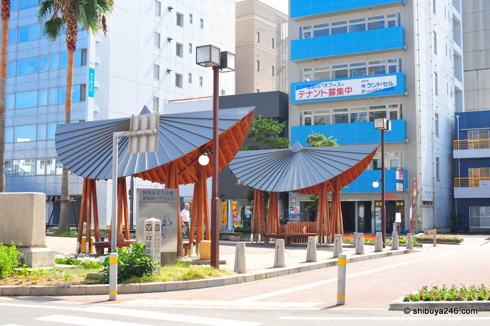 Wooden shelters with curved roofs in a plaza