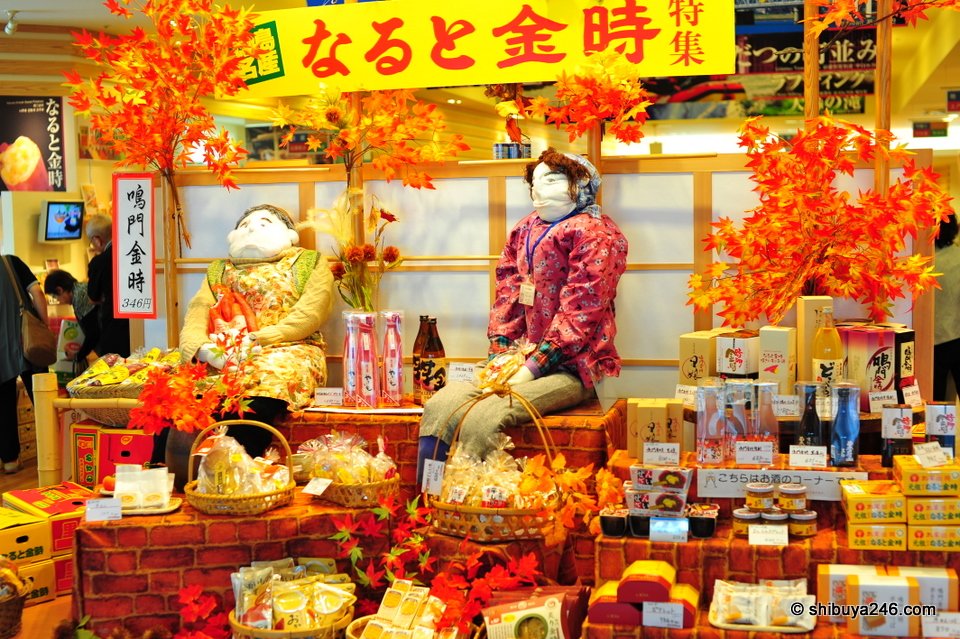 A shop display with dolls and Naruto Kintoki sweet potatoes