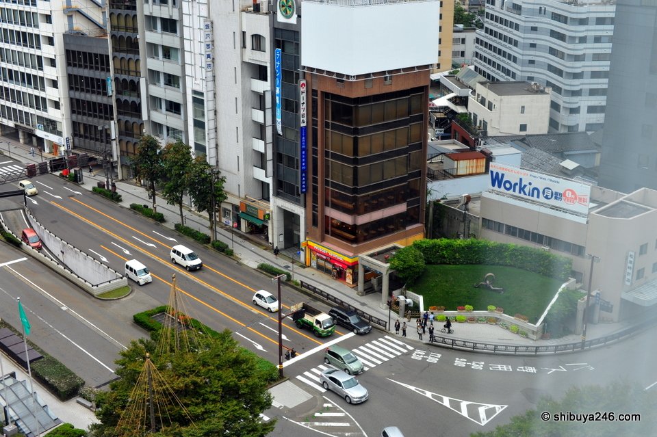 A busy street with tall buildings seen from above