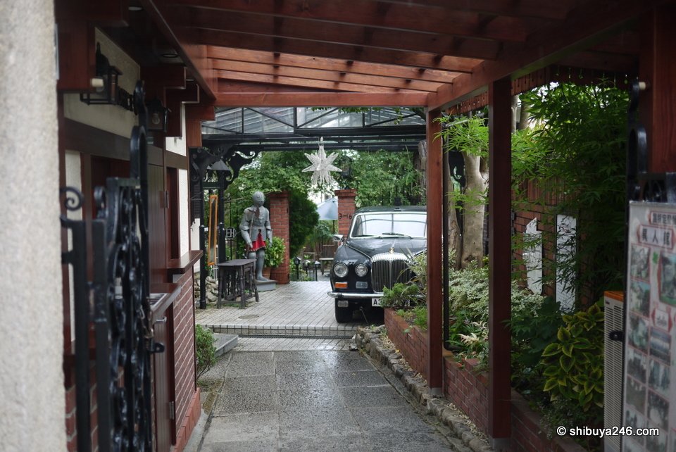 A covered entrance path leading into a garden