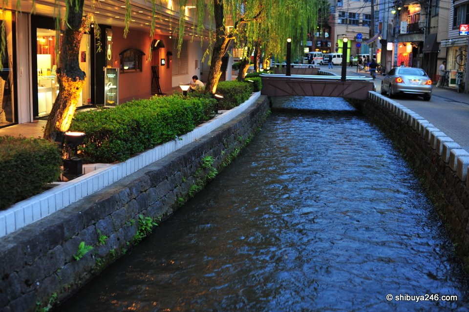 A canal with a small bridge in the evening