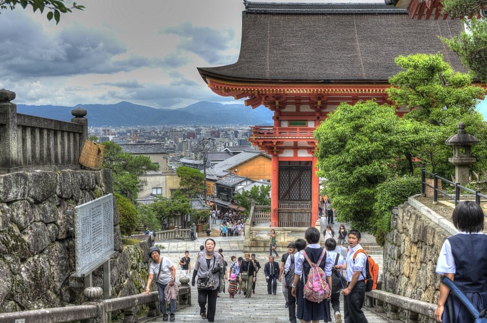 Stone steps beside the red gate, with Kyoto below