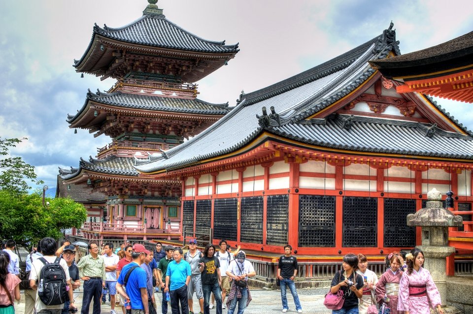 The three-storey pagoda and red temple halls with visitors in front