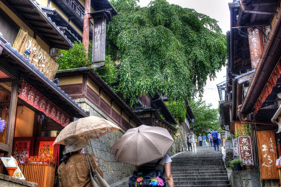 Shops along a stone stairway with people holding parasols