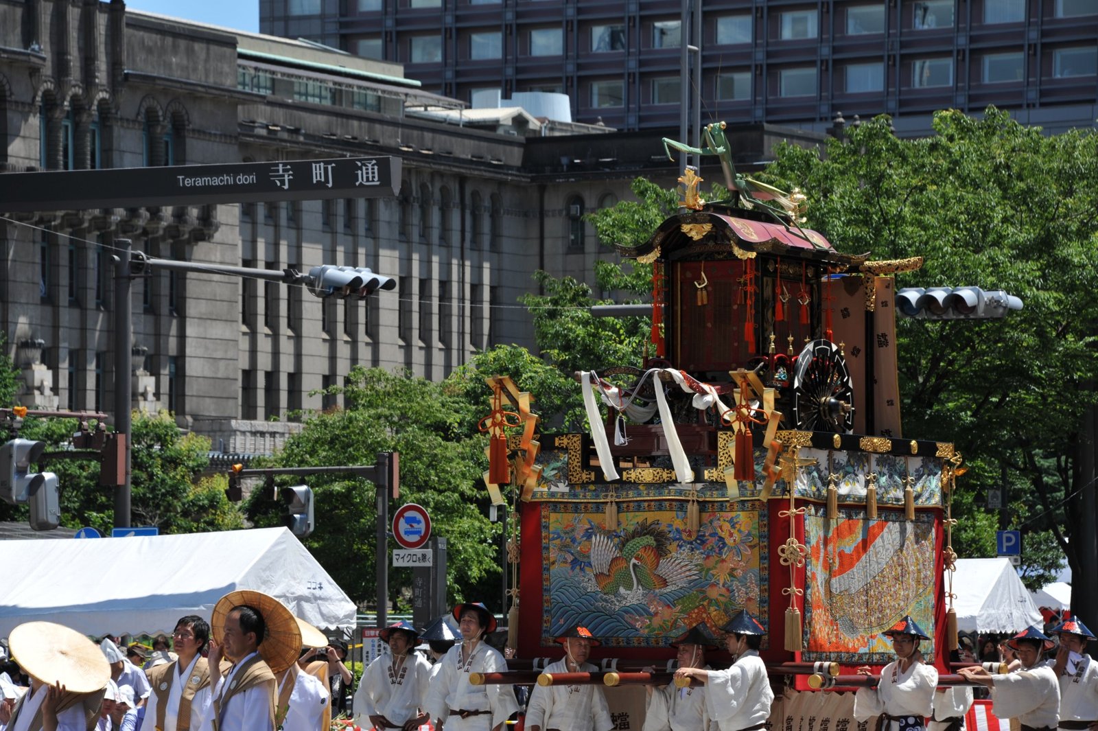 A wooden float with tapestries in front of an office building