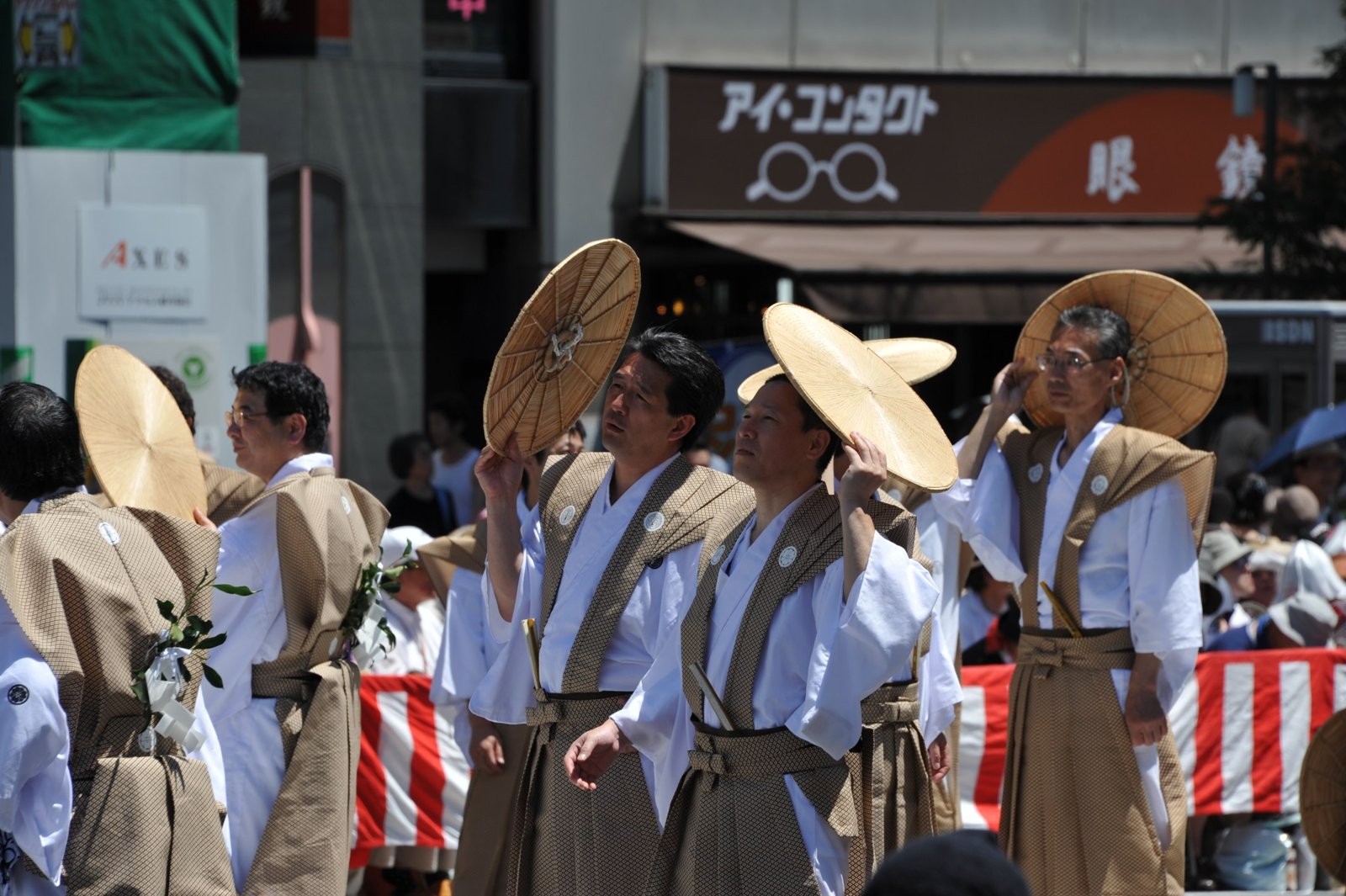 Men in straw hats and white robes walking in the parade