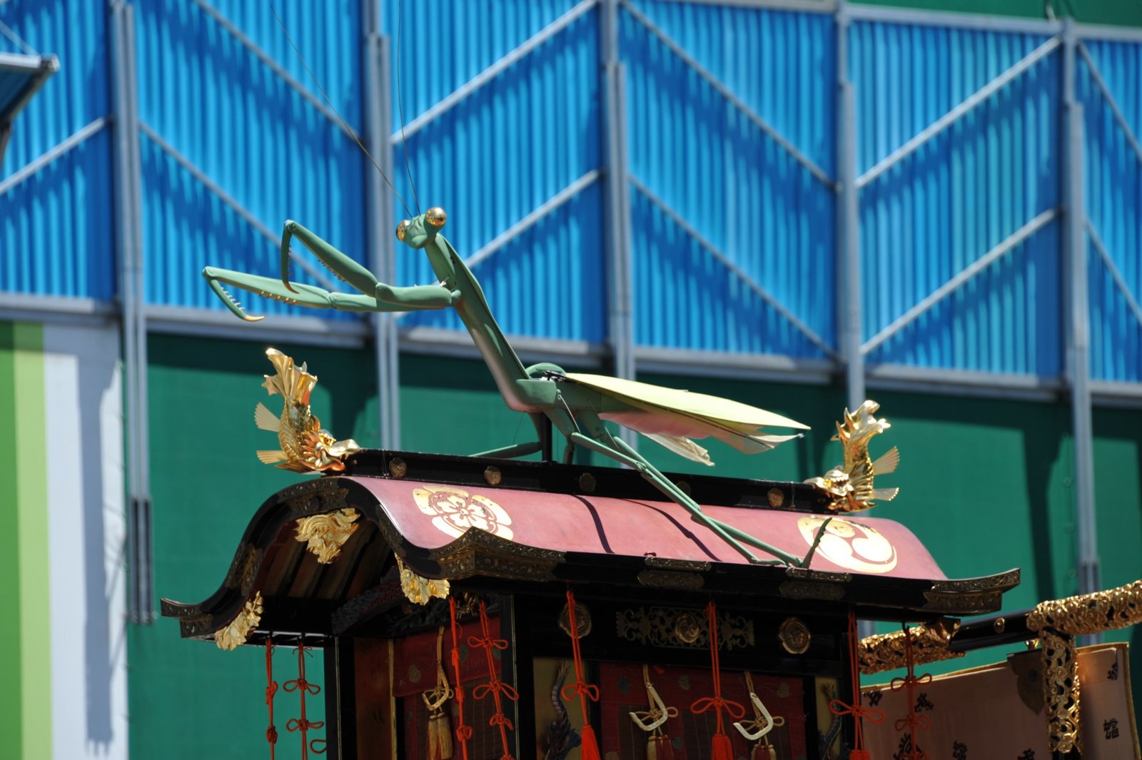 A praying mantis model on top of a float