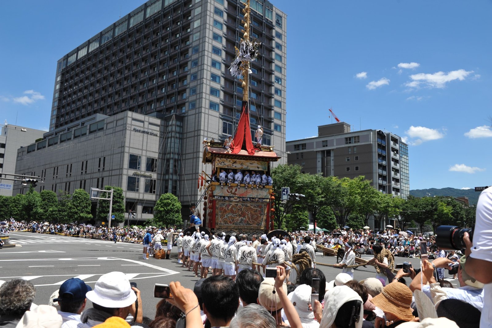 A float on a wide street lined with crowds