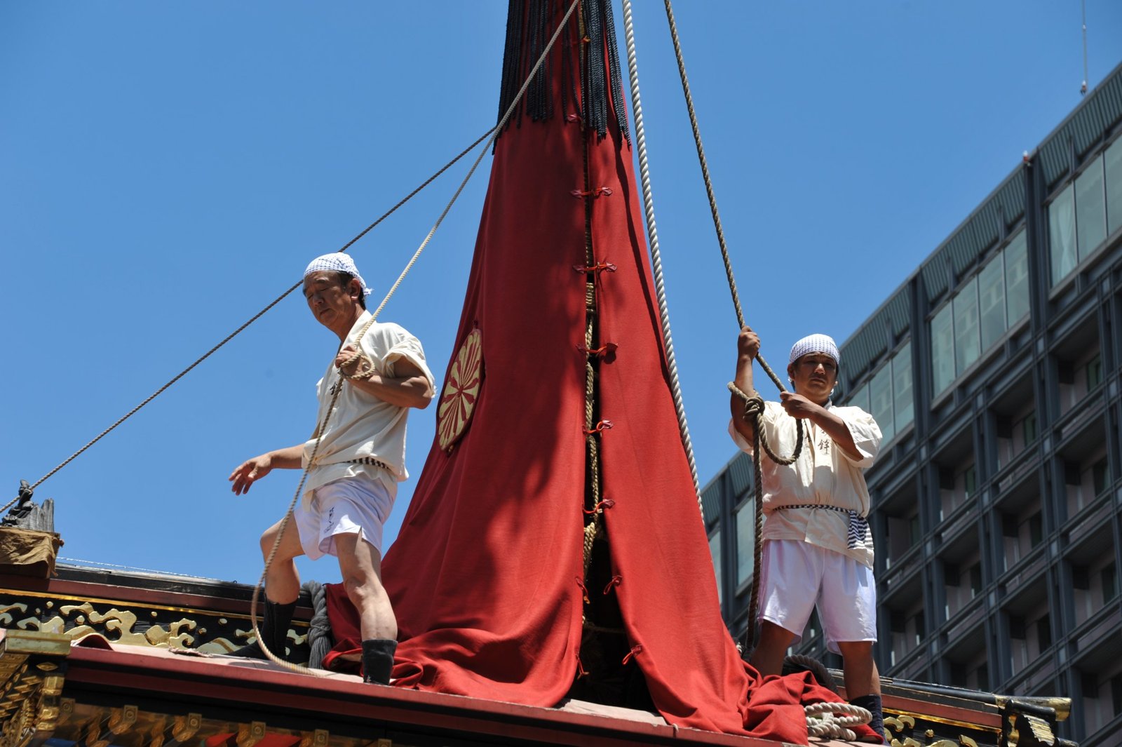 Men standing on top of a float under a red cover