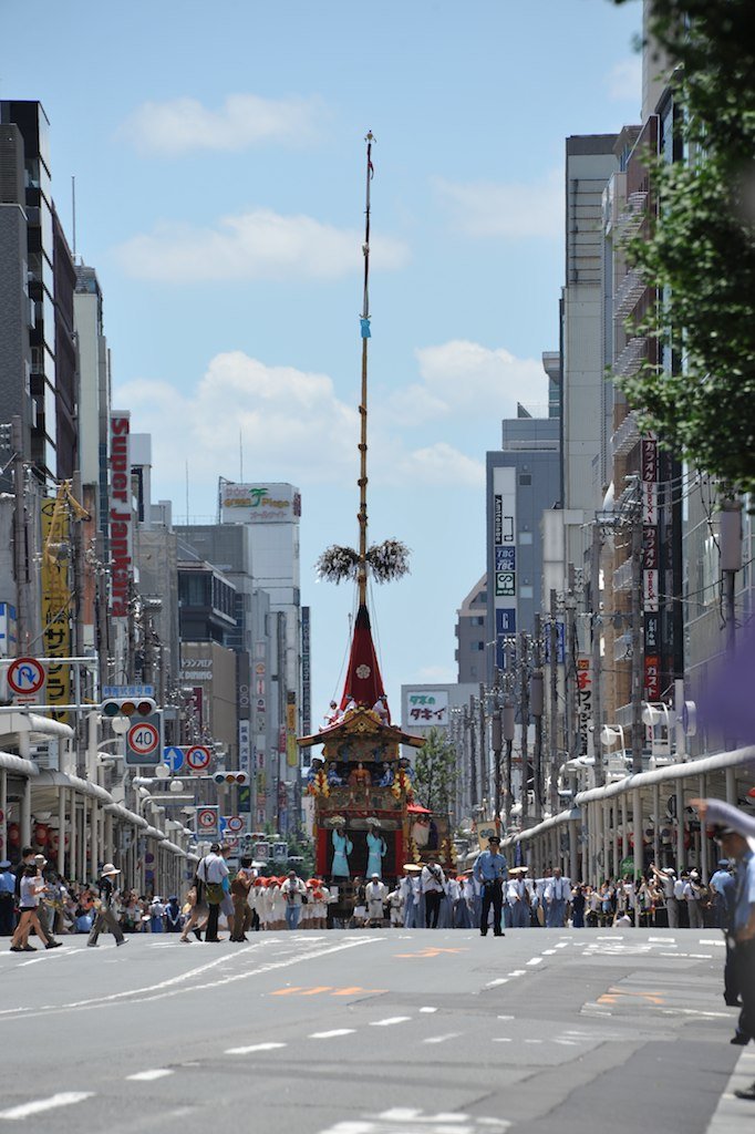 A tall float far down a street between buildings