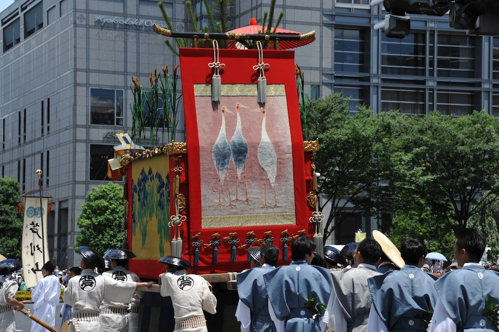 A float with a hanging tapestry and men in blue