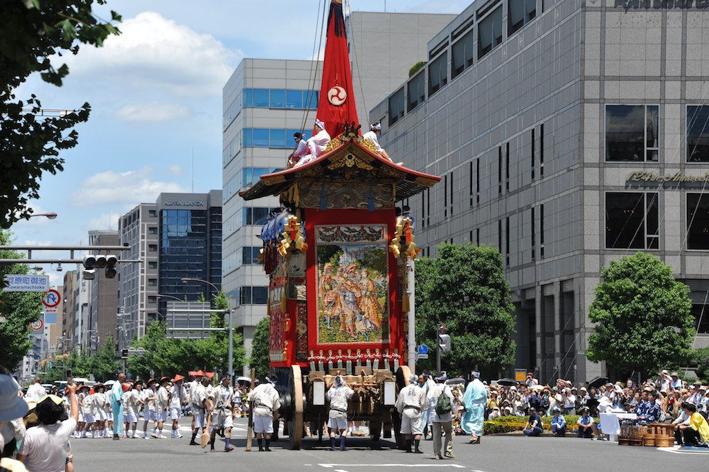 A float heading down a street lined with spectators