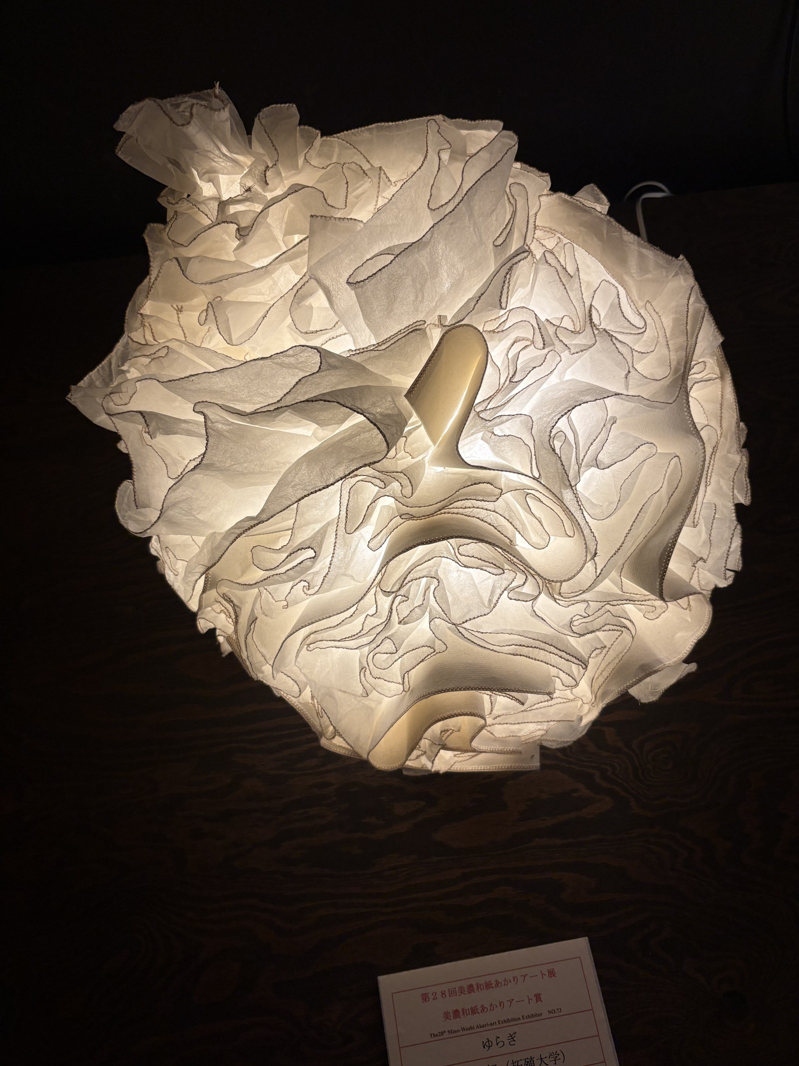 A lamp of crumpled white paper shaped into a ball