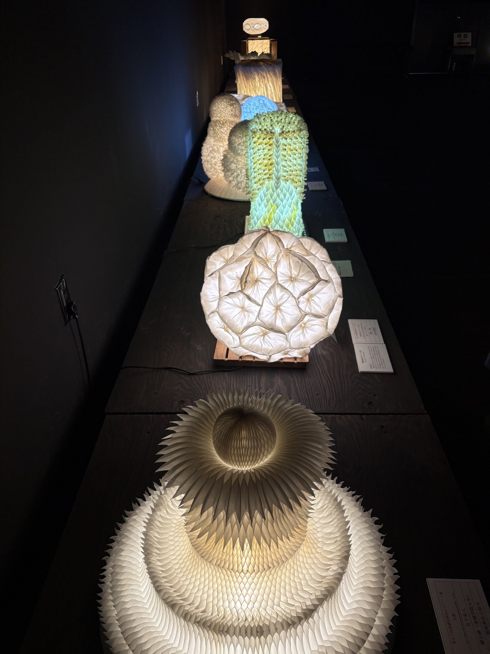 A row of glowing paper lamps along a dark room