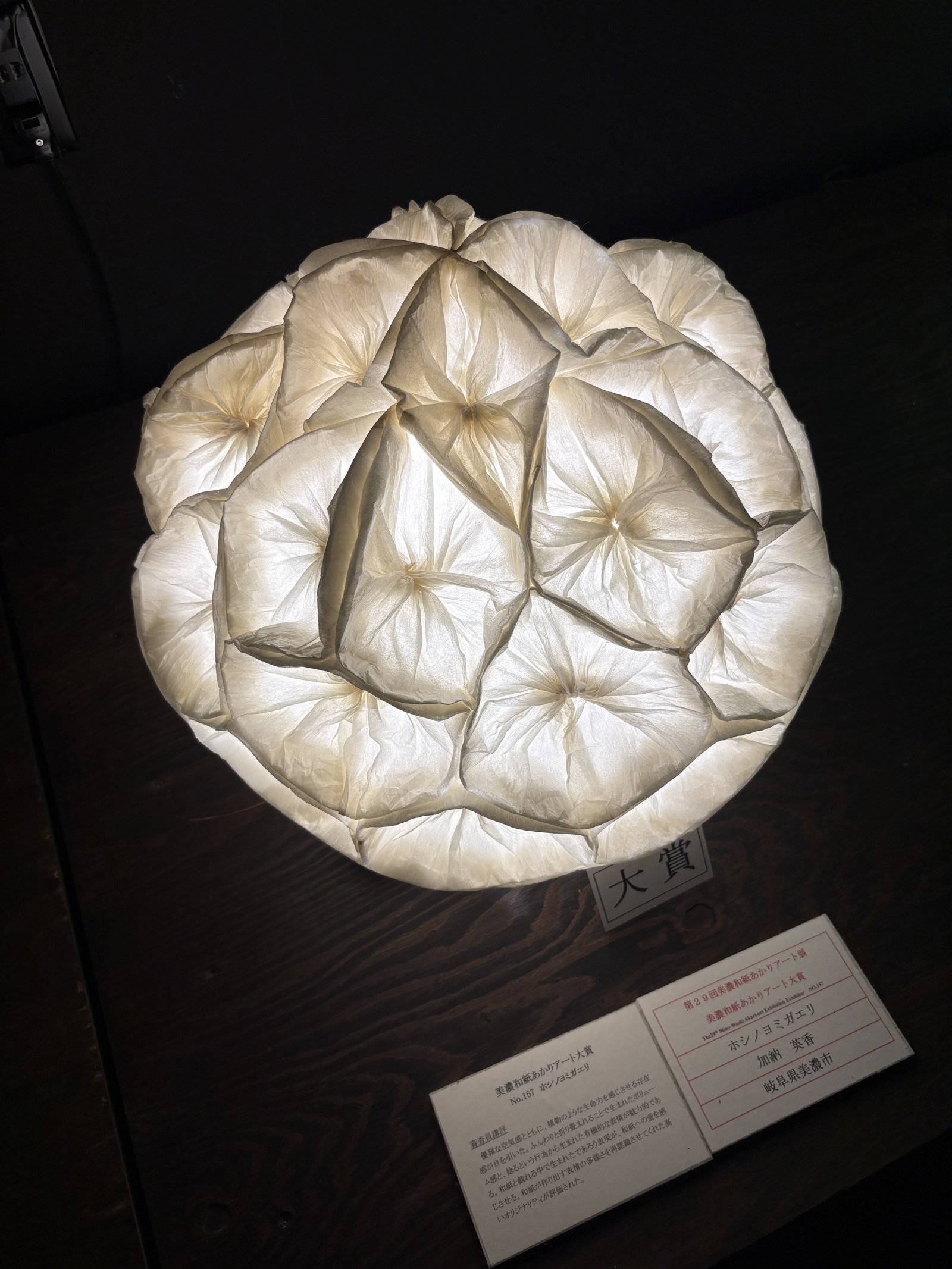 A round lamp of folded white paper with a grand prize sign