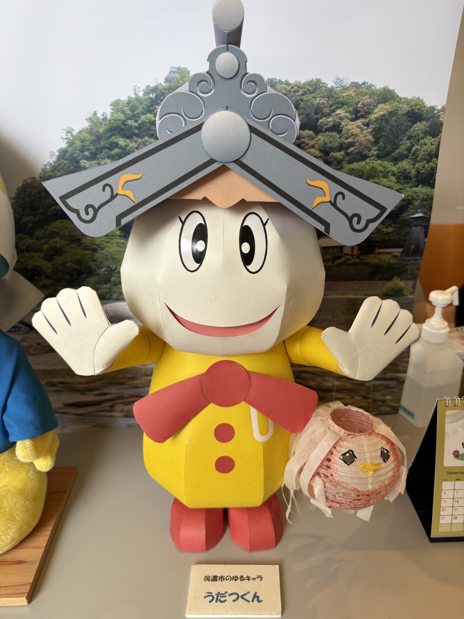 A mascot with a white face and a grey roof on its head