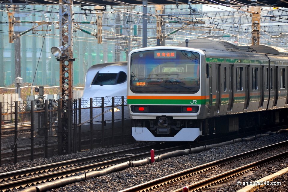 The Shinkansen takes a peak from behind the Tokaido Line. The old and the new. I can easily guess who will win this race.